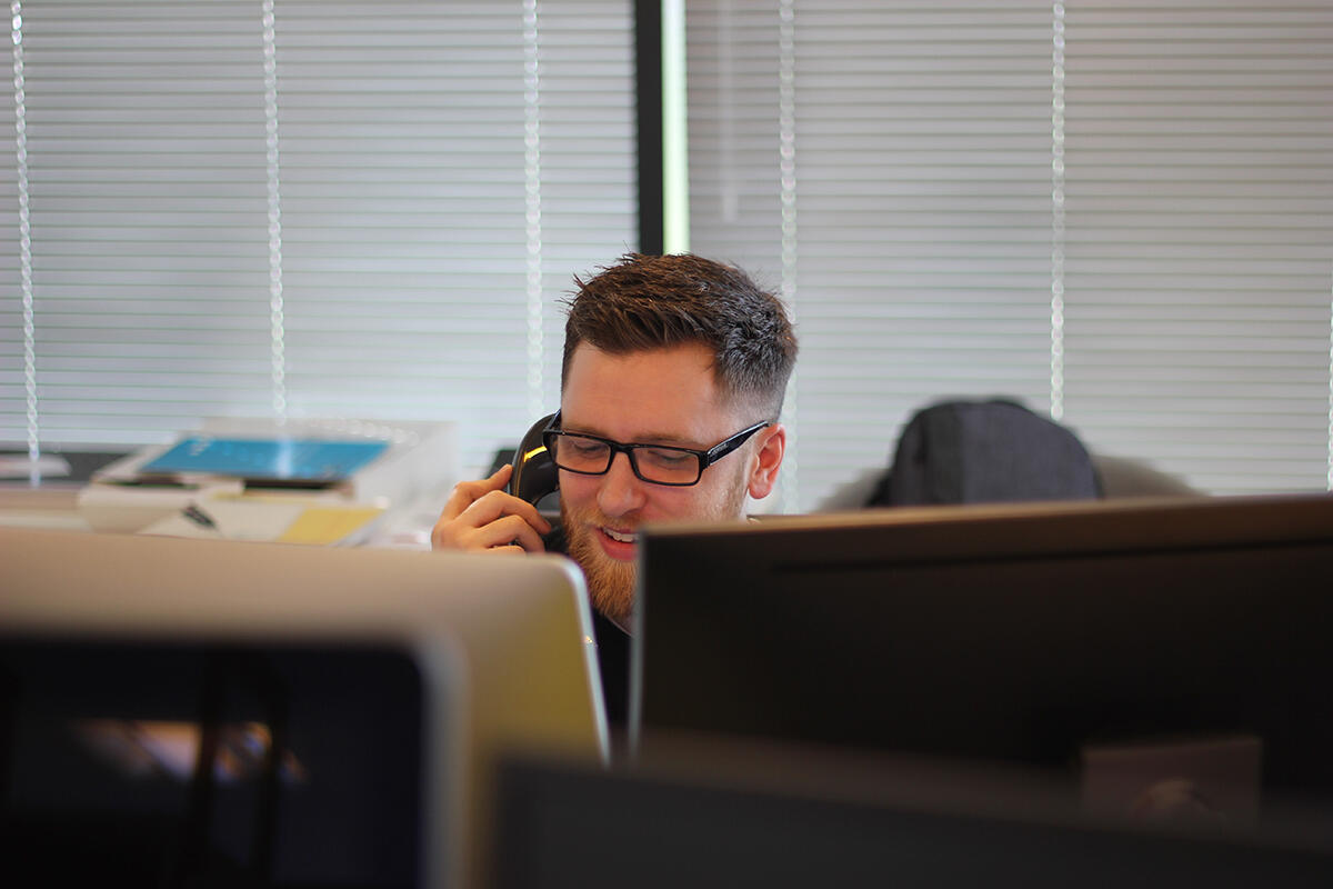 Junger Mann in einem Callcenter.