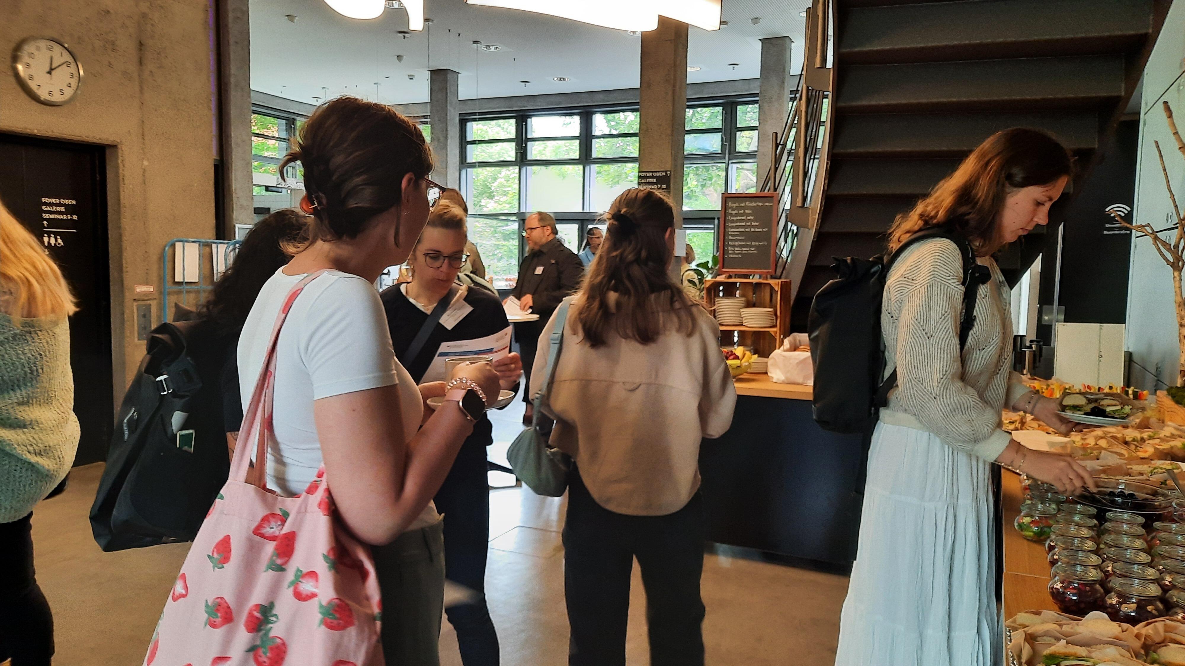 Teilnehmende beim Buffet während einer Pause des Vernetzungstreffens „ZusammenSpiel: Praxis und Wissenschaft – gemeinsam wirksam“.