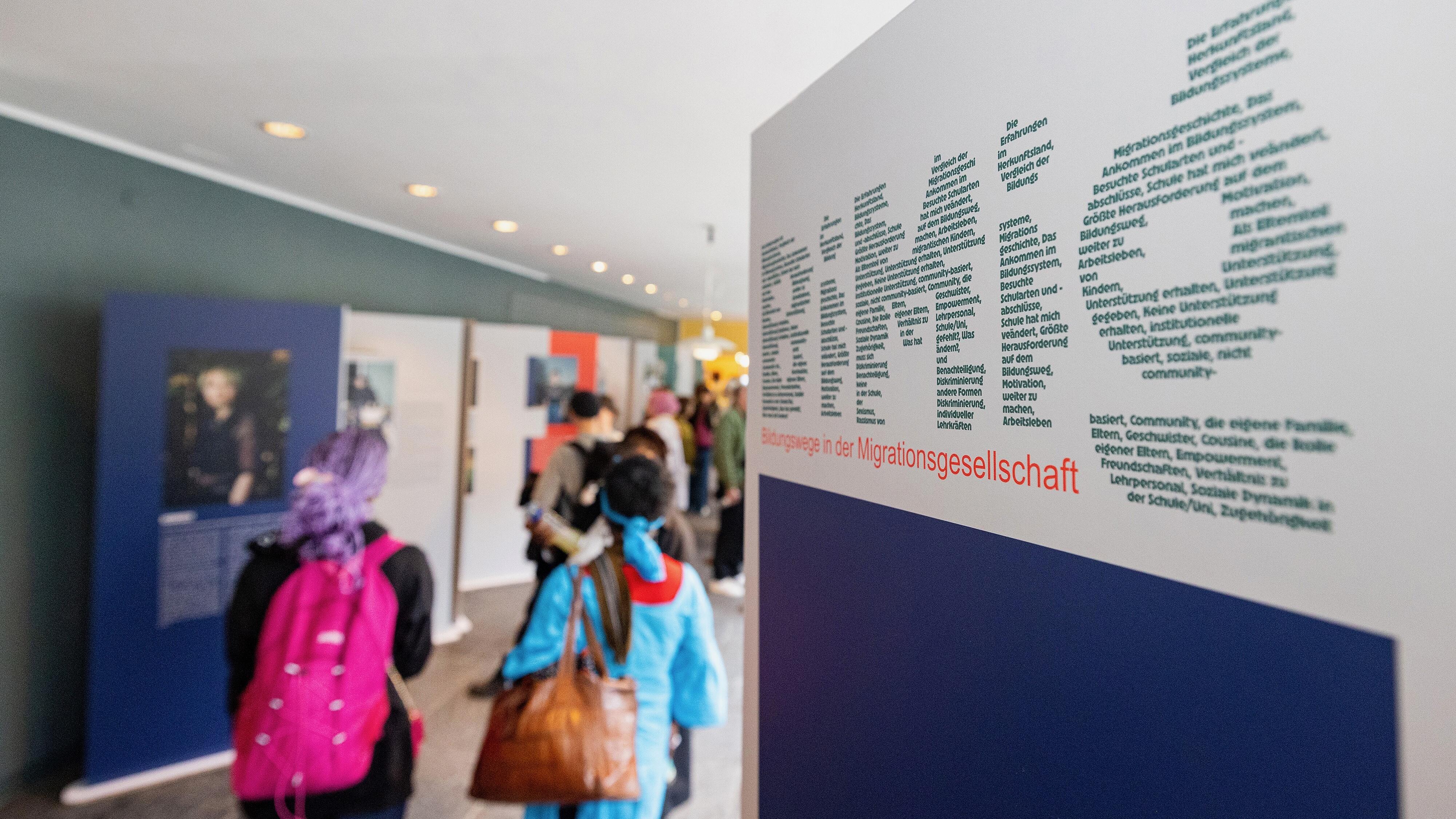 Besucher und Besucherinnen in der Wanderausstellung "Bildungswege in der Migrationsgesellschaft".