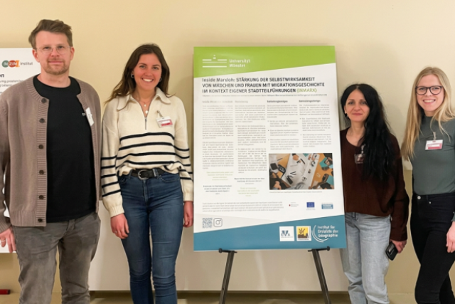 Vier Mitglieder der Projektgruppe InsideMarx – ein Mann und drei Frauen – stehen vor einem wissenschaftlichen Poster und präsentieren ihre gemeinsame Forschungsarbeit.