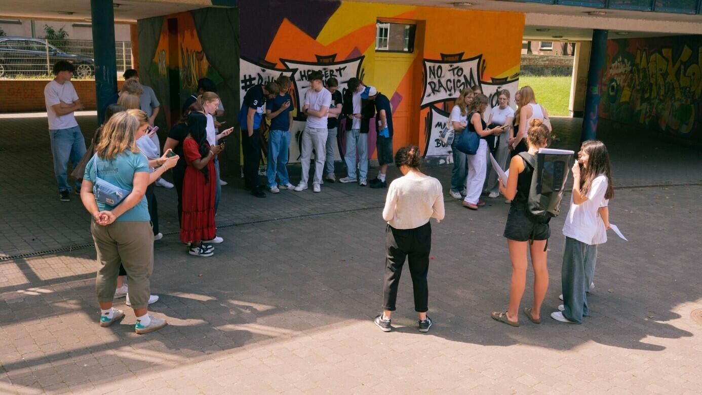 Mehrere Jugendliche der Mädchen-AG Inside Marxloh stehen gemeinsam auf einem Platz und unterhalten sich.