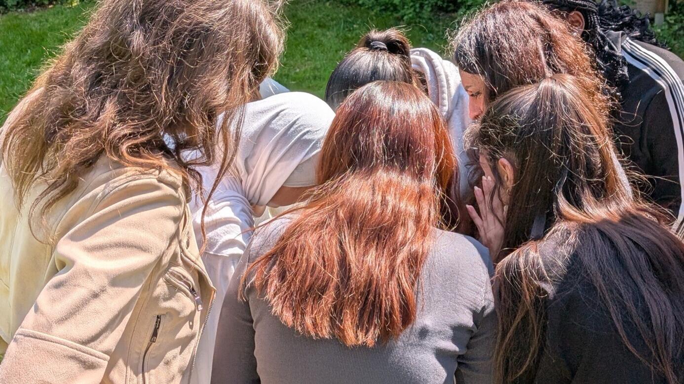 Mehrere weibliche Jugendliche der Mädchen-AG Inside Marxloh stehen mit dem Rücken zur Kamera und betrachten etwas, das im Bild nicht zu sehen ist.