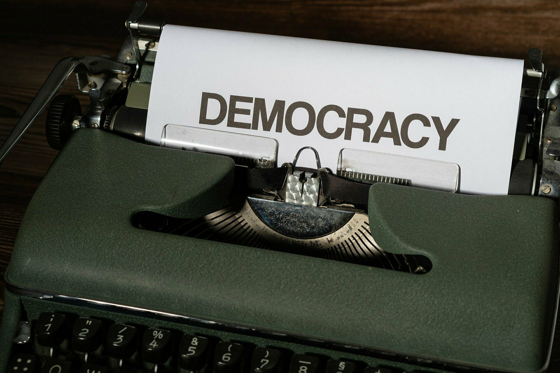 Ein Blatt in einer Schreibmaschine mit der Aufschrift DEMOCRACY (Demokratie).
