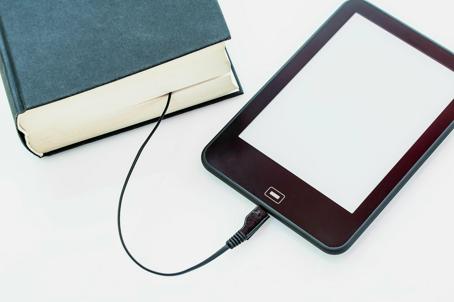 E-Book, das über ein Kabel symbolisch mit einem Buch verbunden ist.