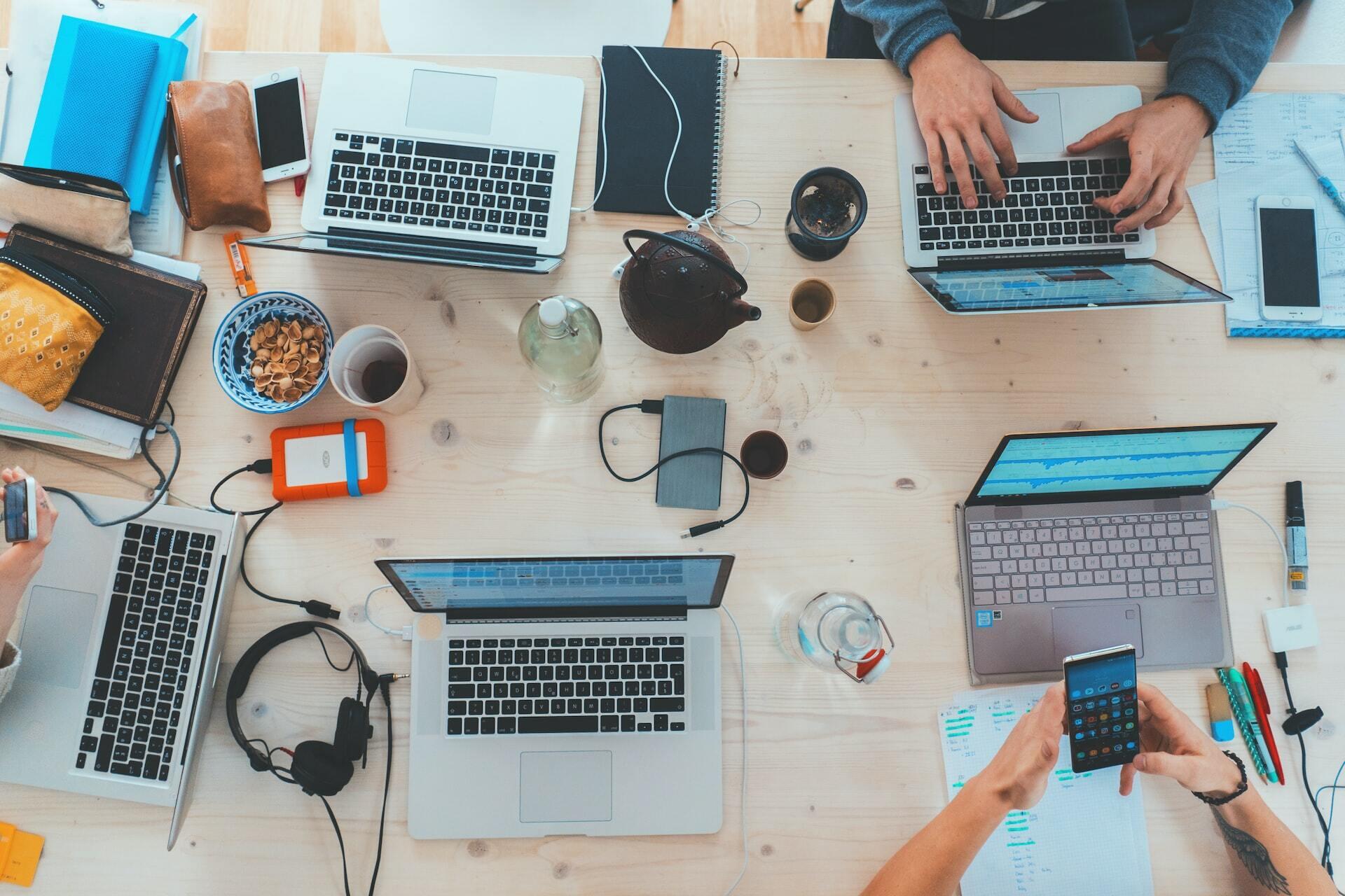 Schreibtisch mit Laptops und Kopfhörern