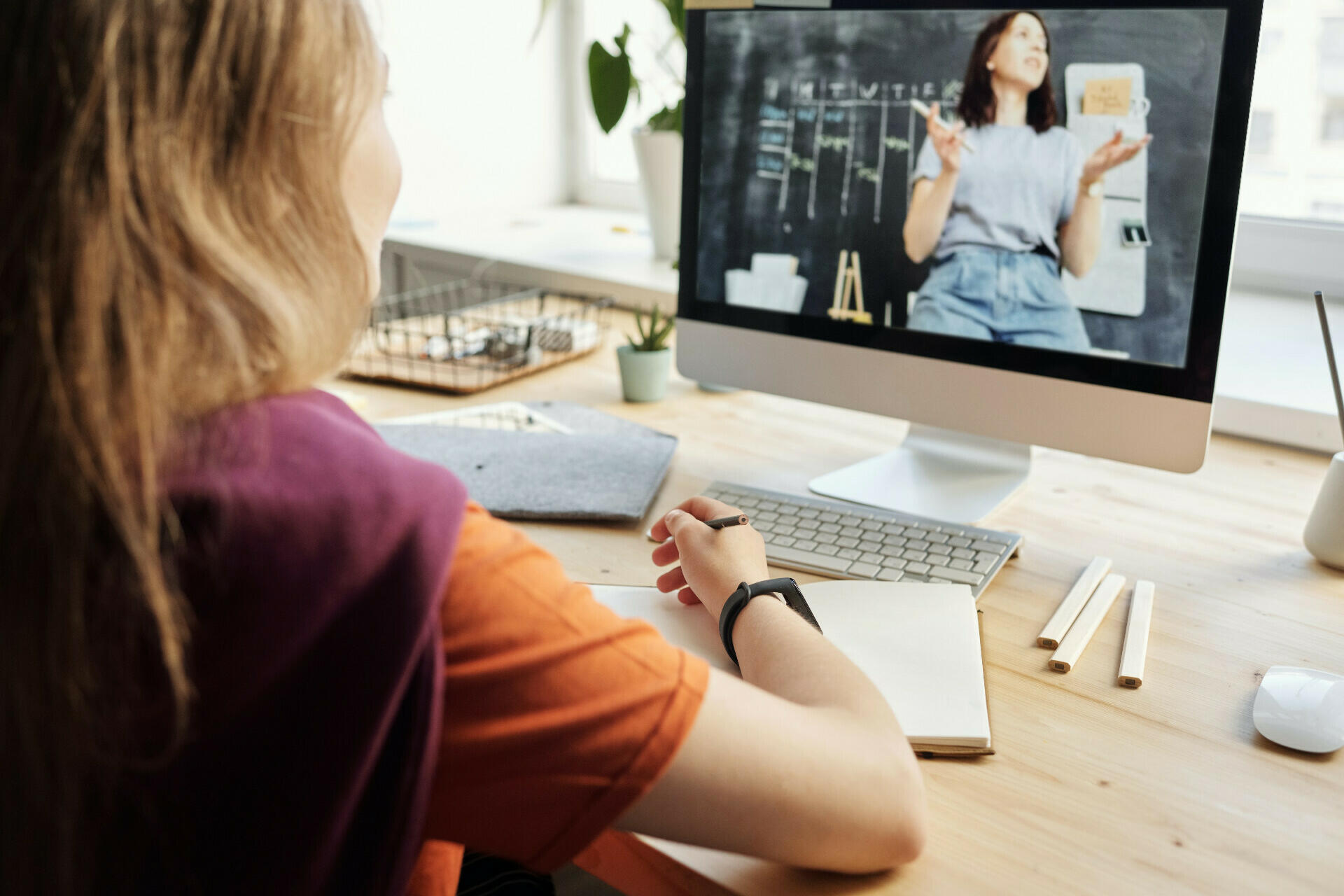 Mädchen sitzt am Laptop und lernt online