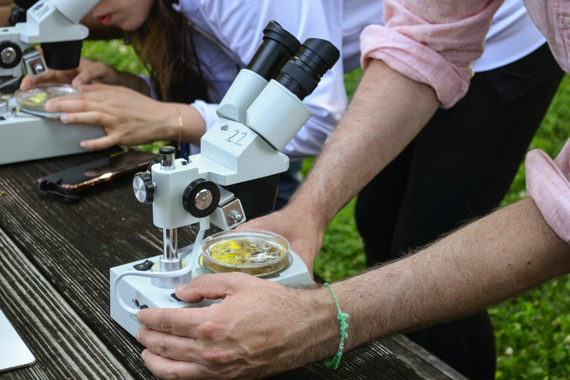 Hände umfassen ein Mikroskop