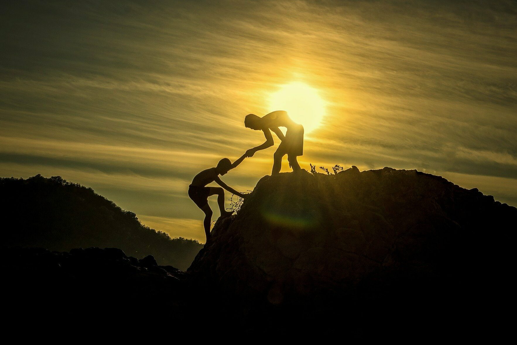 Zwei Jungs, die einander helfen, den Berg hochzukommen
