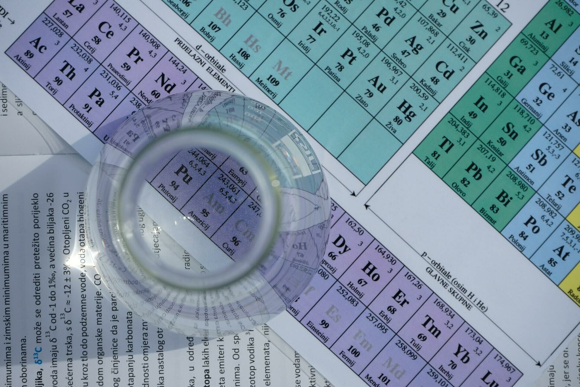Reagenzglas steht auf einem Tisch mit chemischer Formeltabelle