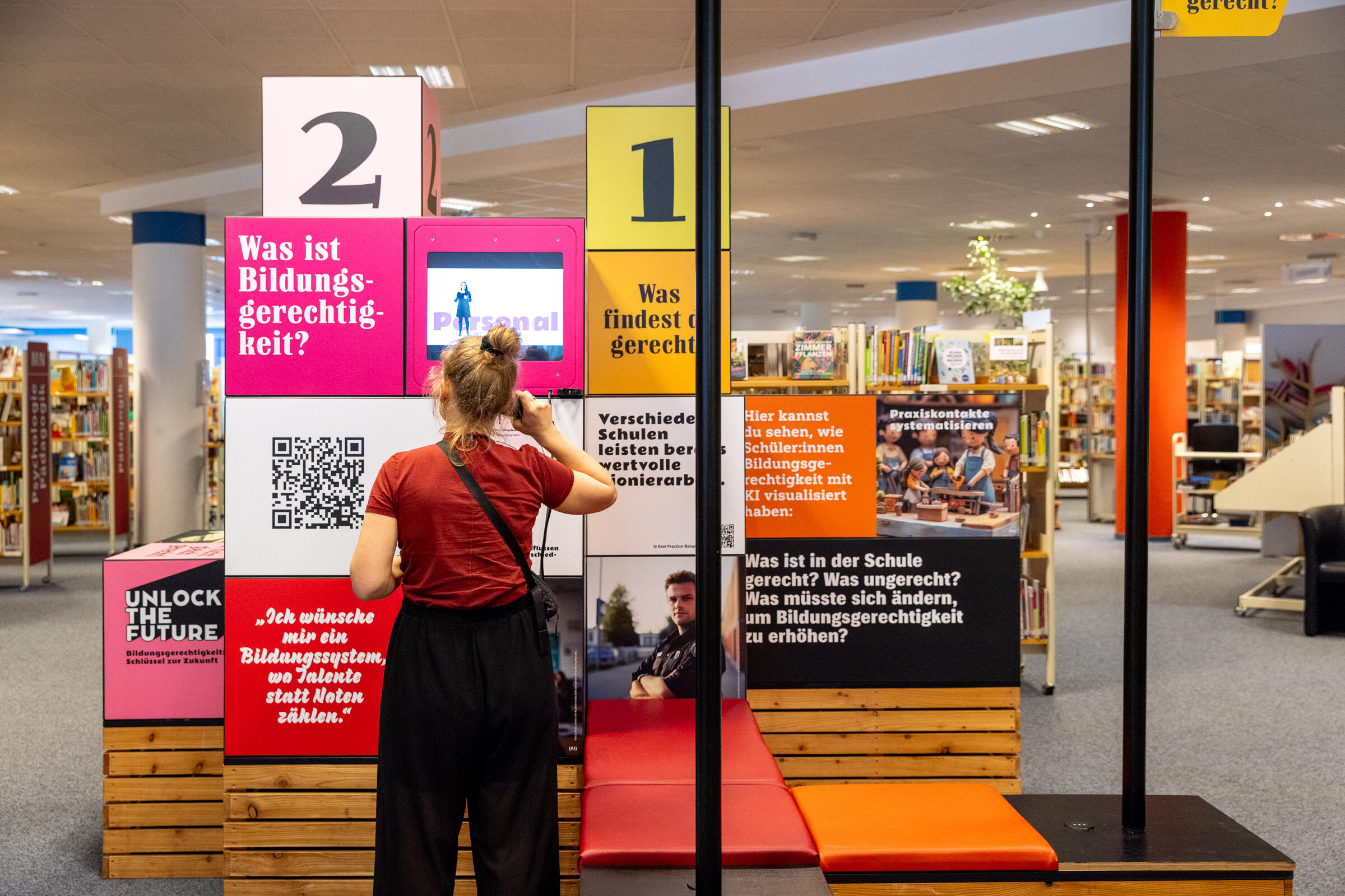 Menschen betrachten eine Ausstellung zu Bildungsgerechtigkeit