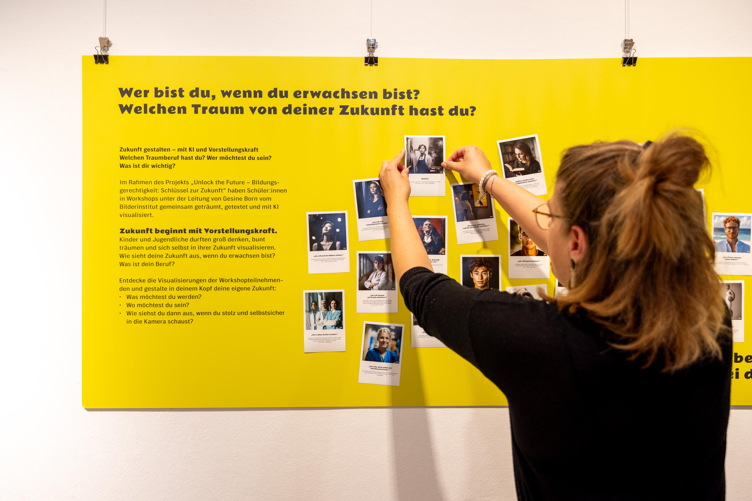 Frau befestigt Fotos in Ausstellung