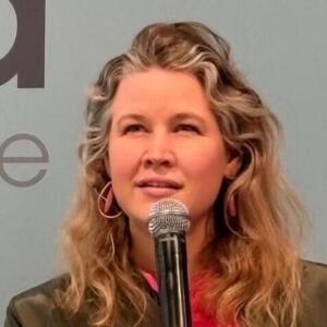 Nikola Poitzmann mit Mikrofon in der Hand, an einem Rednerpult der didacta Bildungsmesse.