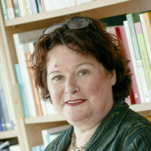 Abbildung von Frau Prof. Dr. Ingrid Gogolin vor einem Bücherregal.