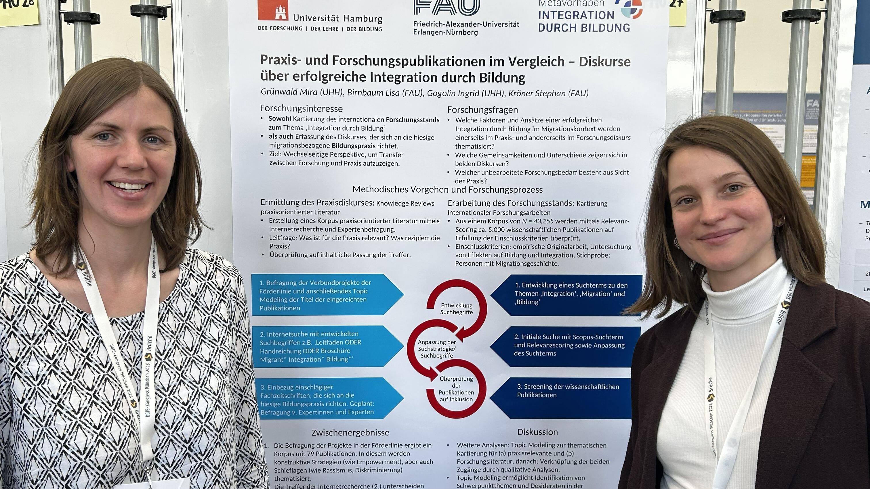 Zwei Frauen stehen vor einem Poster.