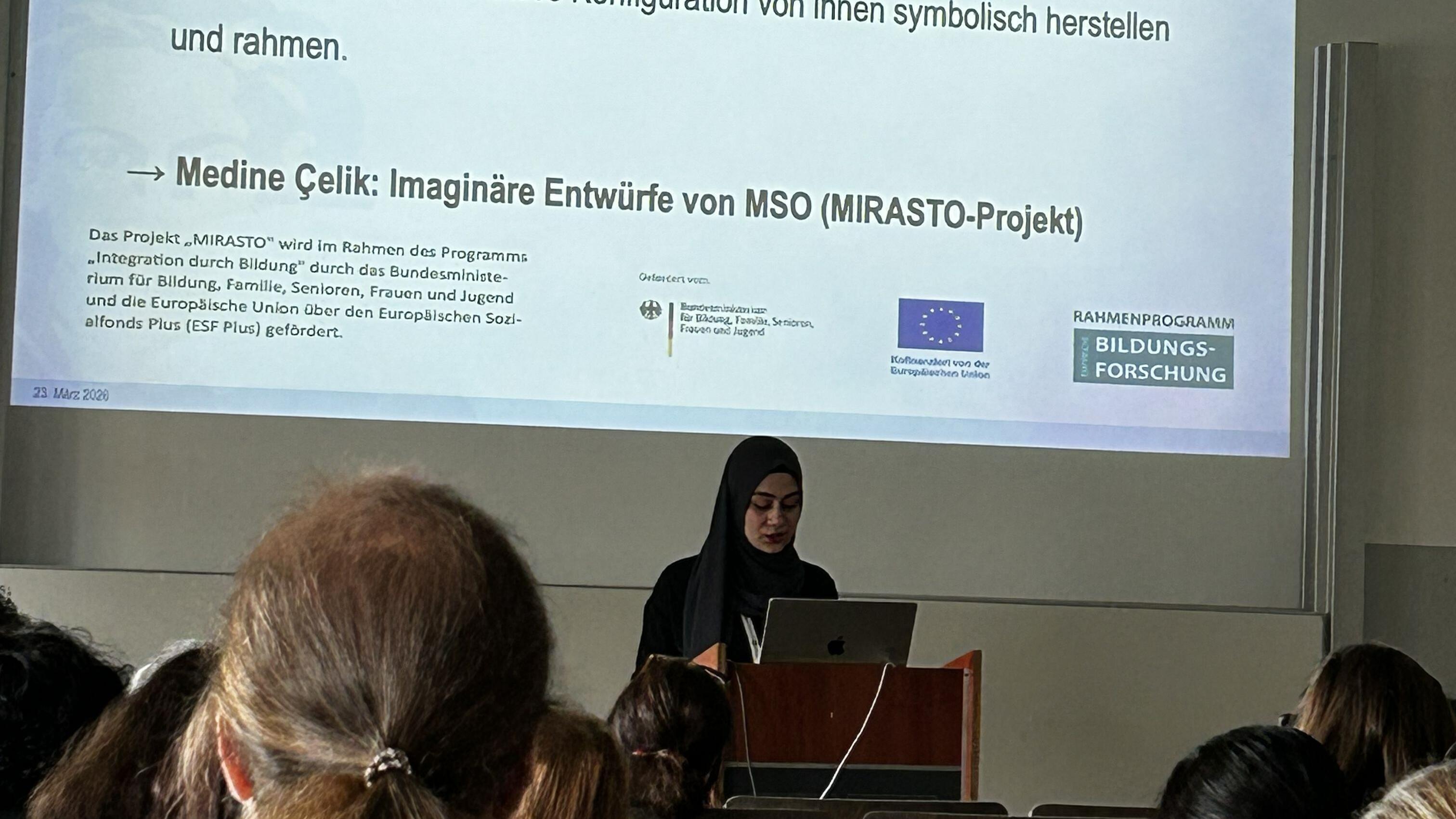Medine Celik hält eine Präsentation in einem Saal vor Publikum.