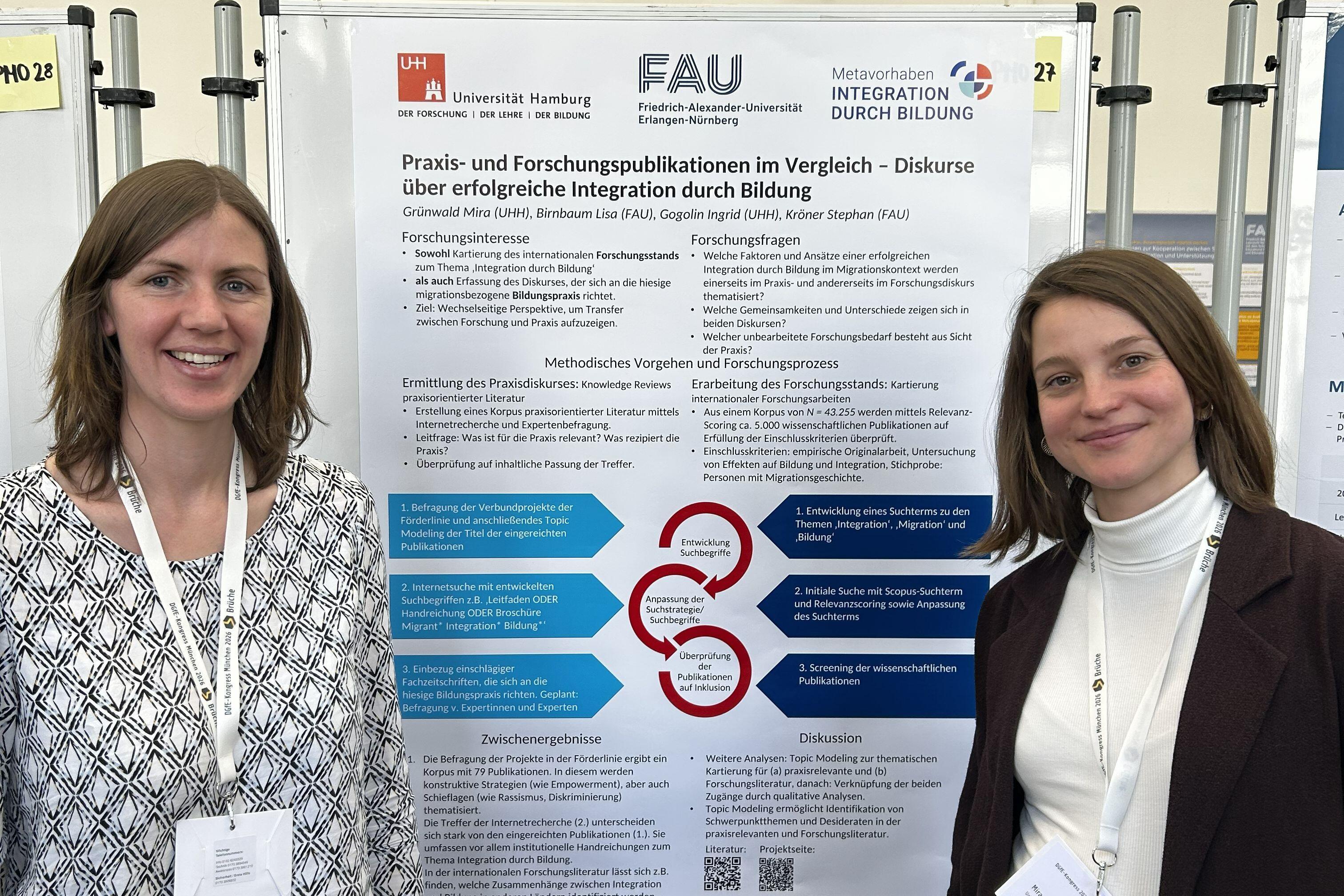 Zwei Frauen stehen vor einem Poster.