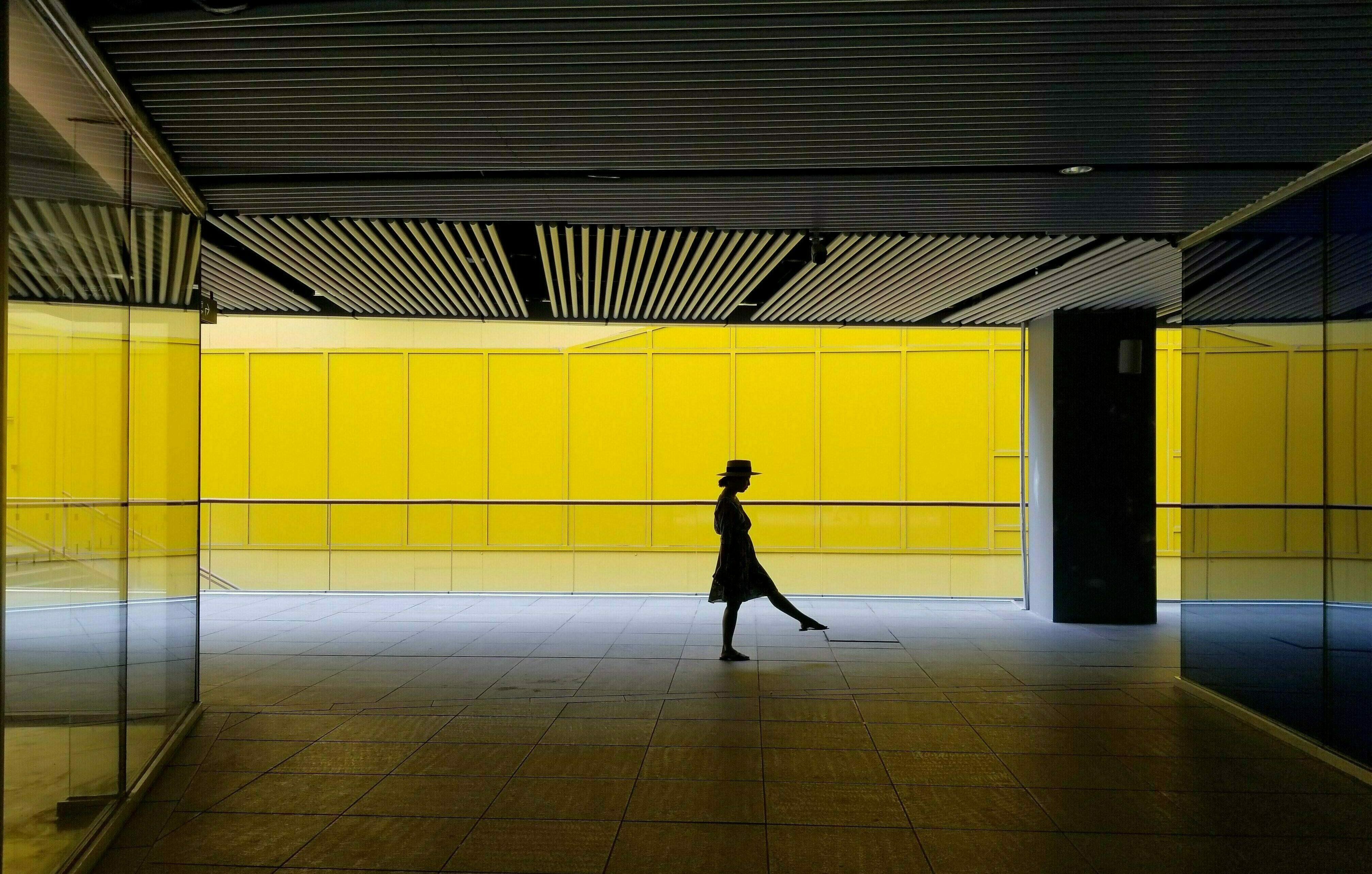 Silhouette einer Frau in einer gelben U-Bahn.