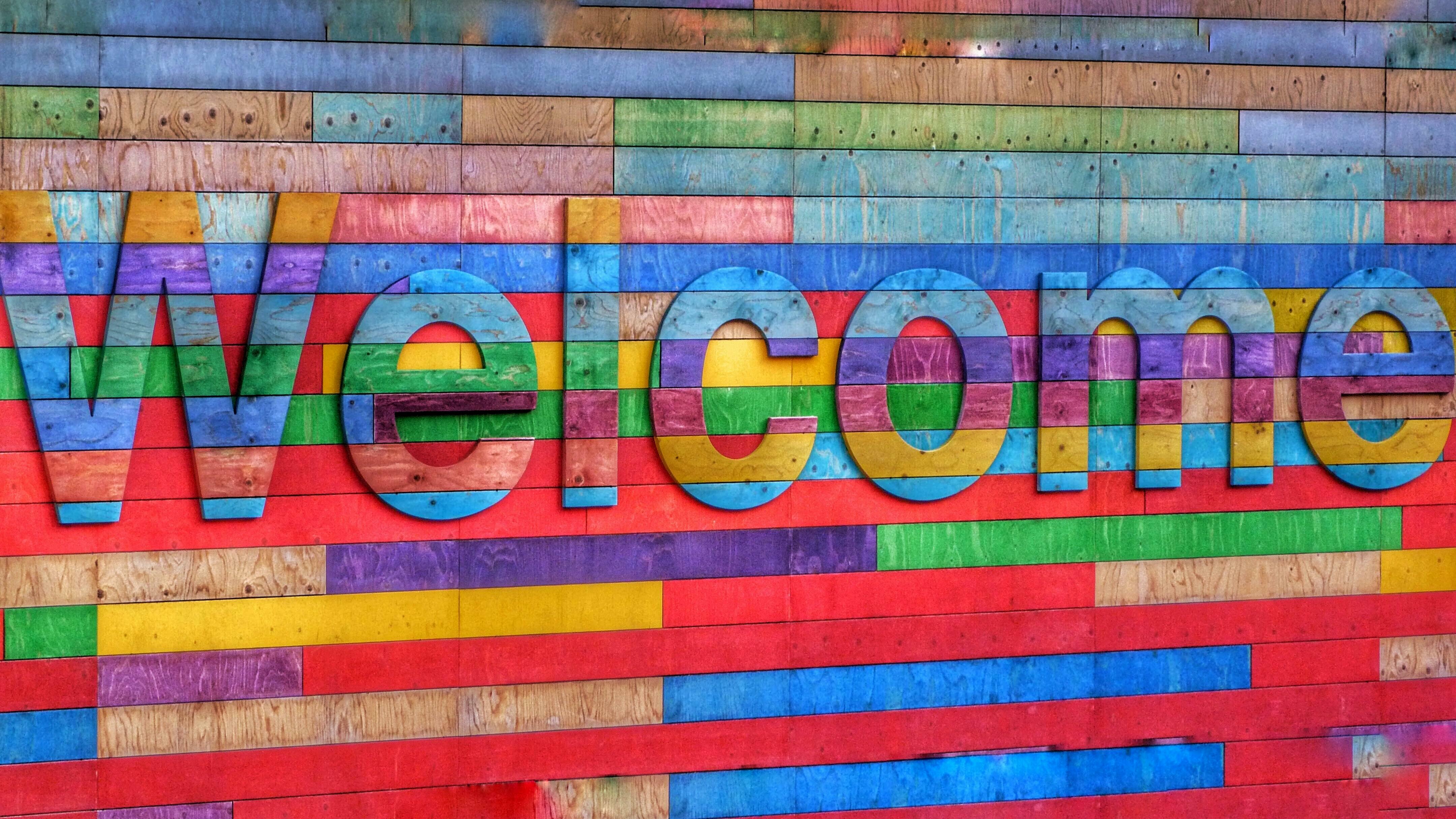 Mehrsprachigkeit: Aufschrift Welcome vor buntem Hintergrund