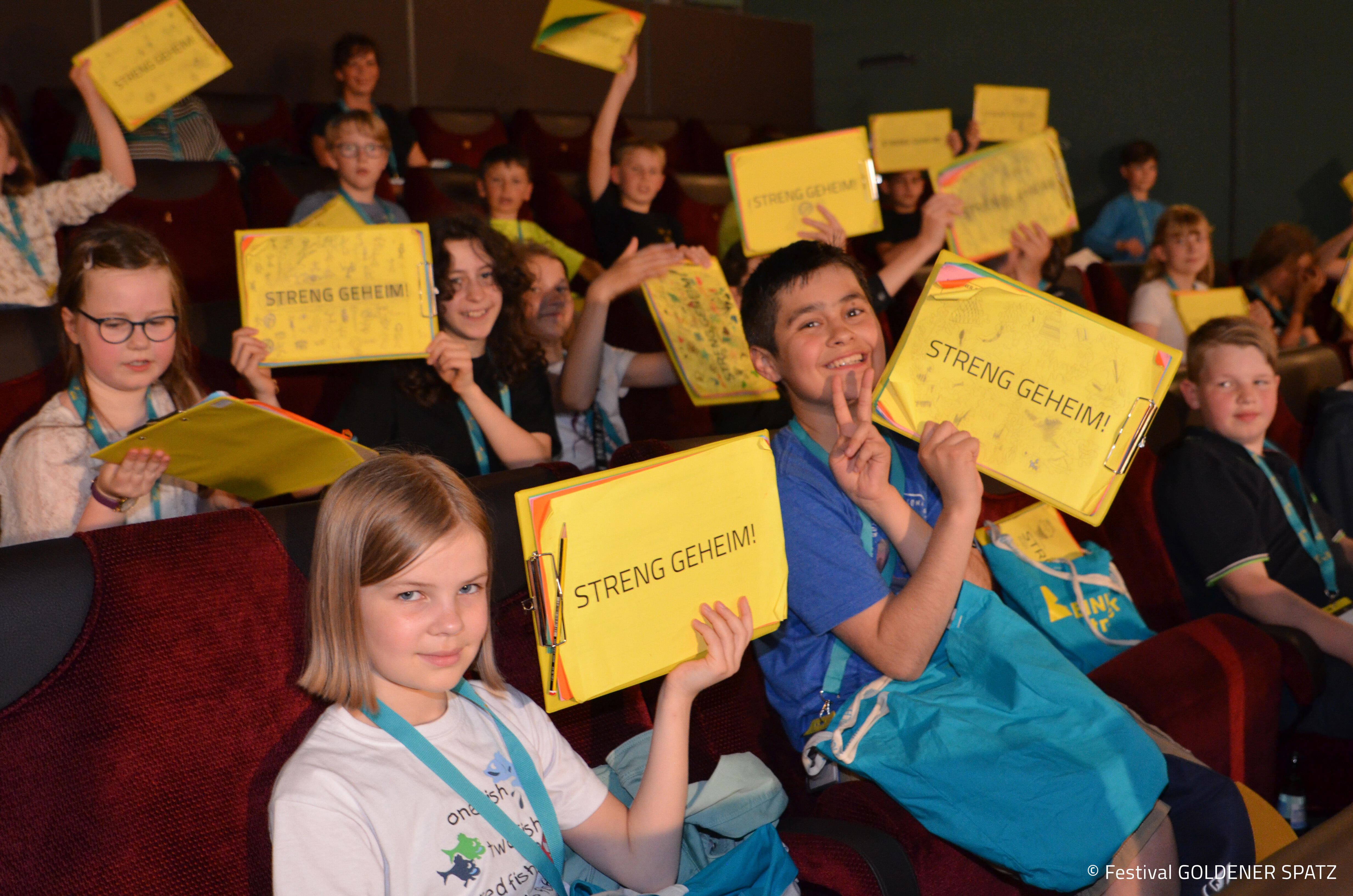 Kinder halten Schild hoch "streng geheim"