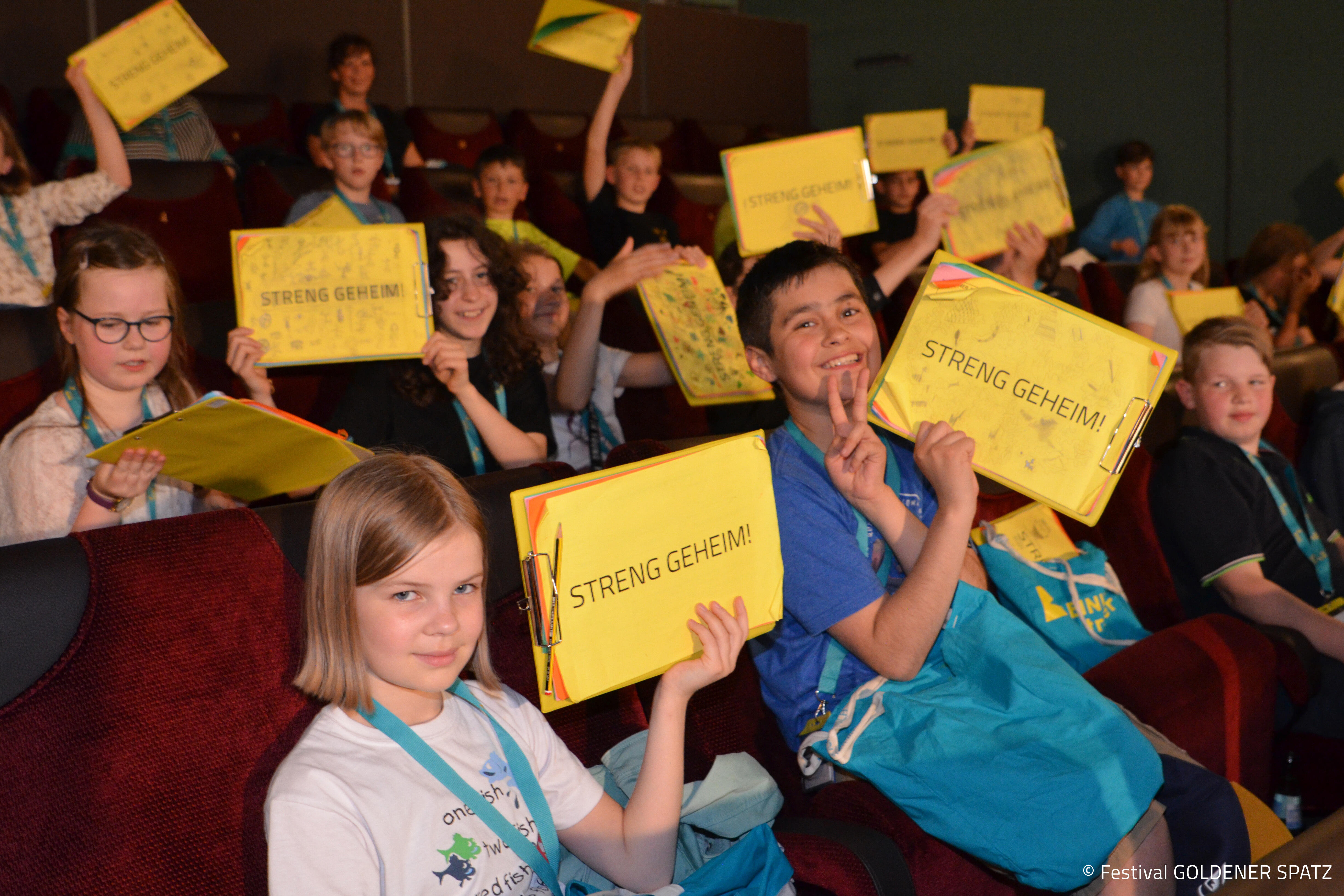 Kinder halten Schild hoch "streng geheim"