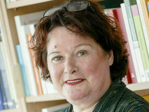 Abbildung von Frau Prof. Dr. Ingrid Gogolin vor einem Bücherregal.