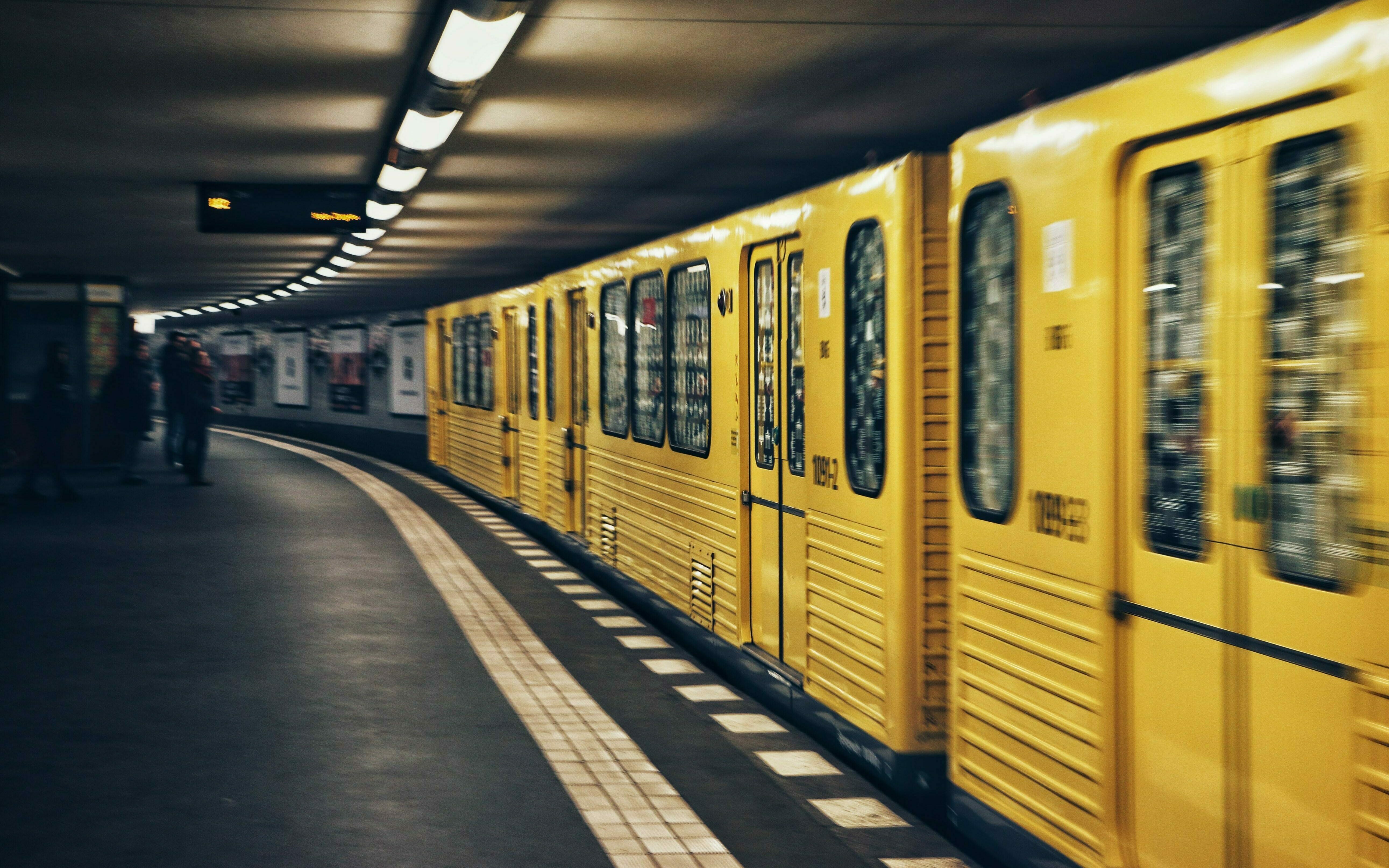 Eine gelbe U-Bahn, die Fahrt aufnimmt.