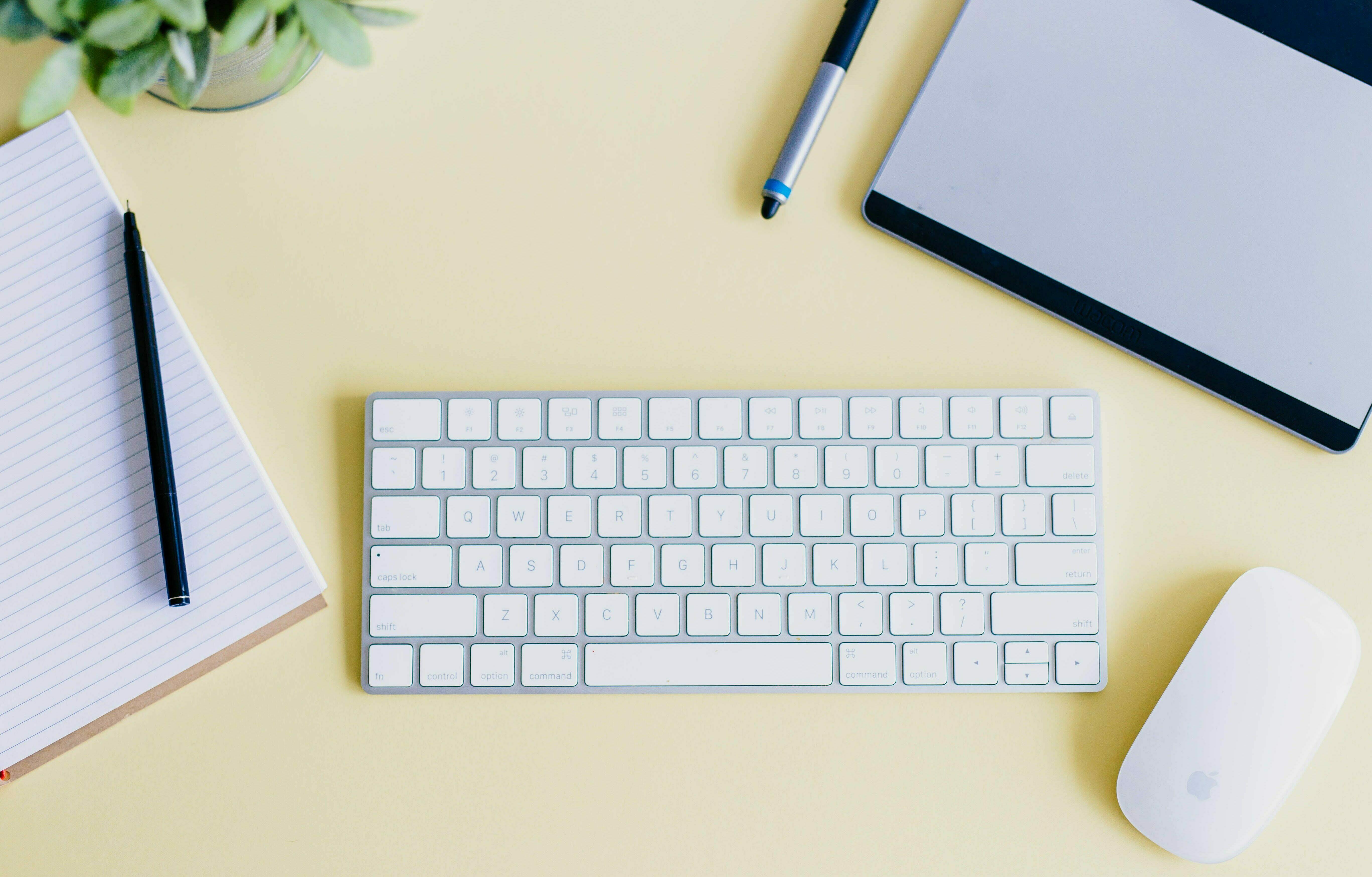 Schreibtisch mit Tastatur, Maus, Stift und Block