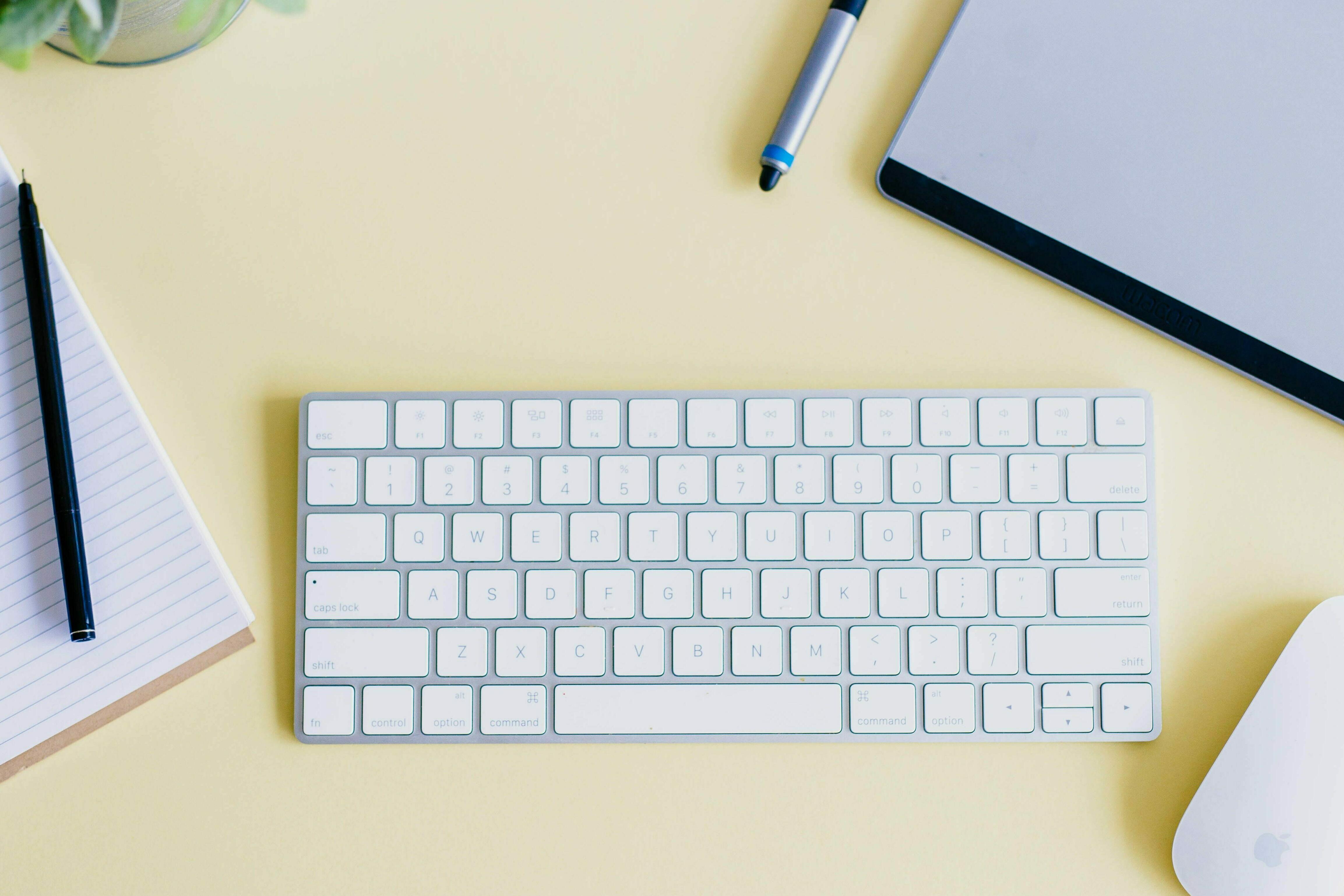 Schreibtisch mit Tastatur, Maus, Stift und Block