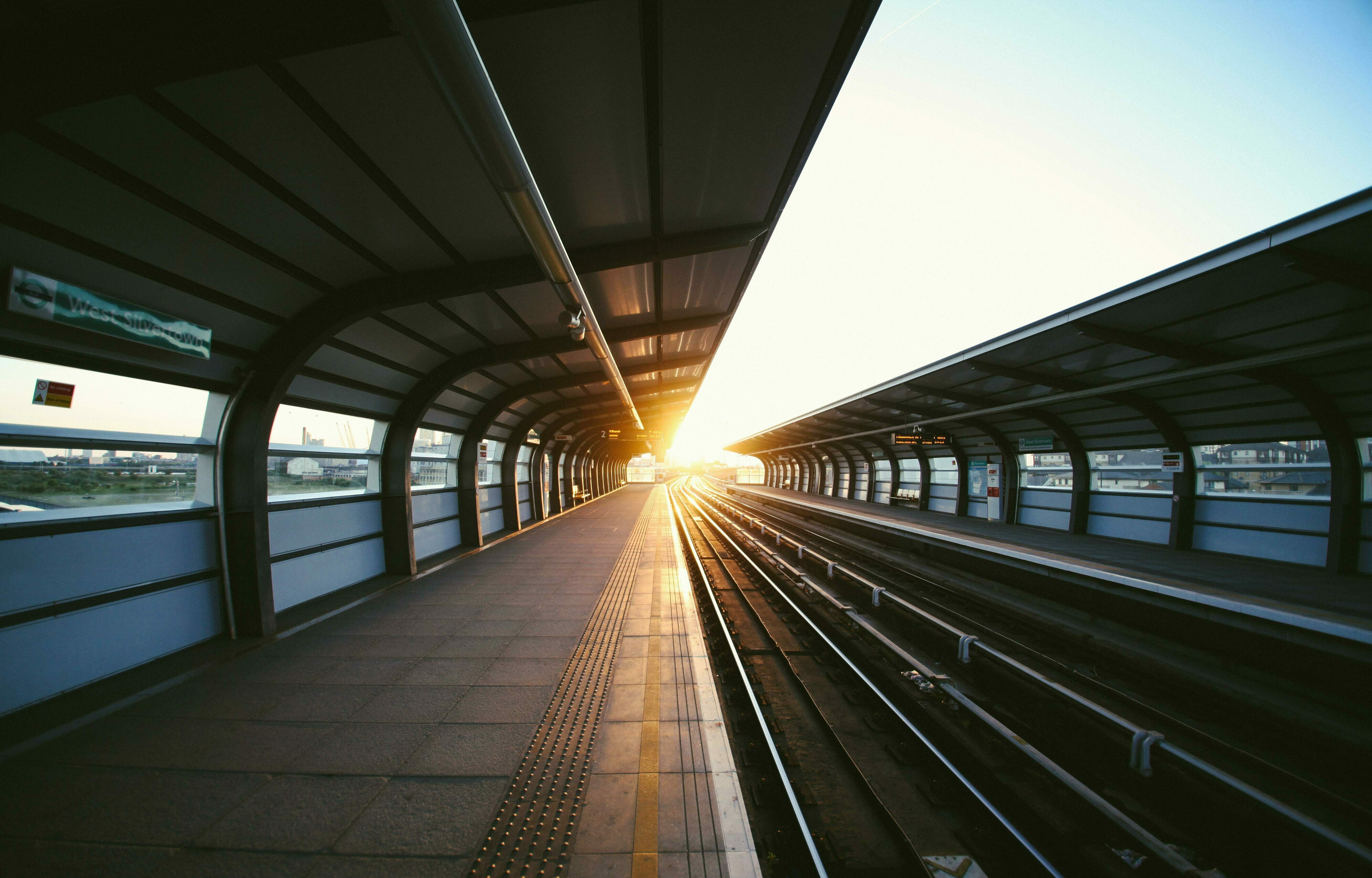 Ein langer, leerer Bahnsteig vor untergehender Sonne.