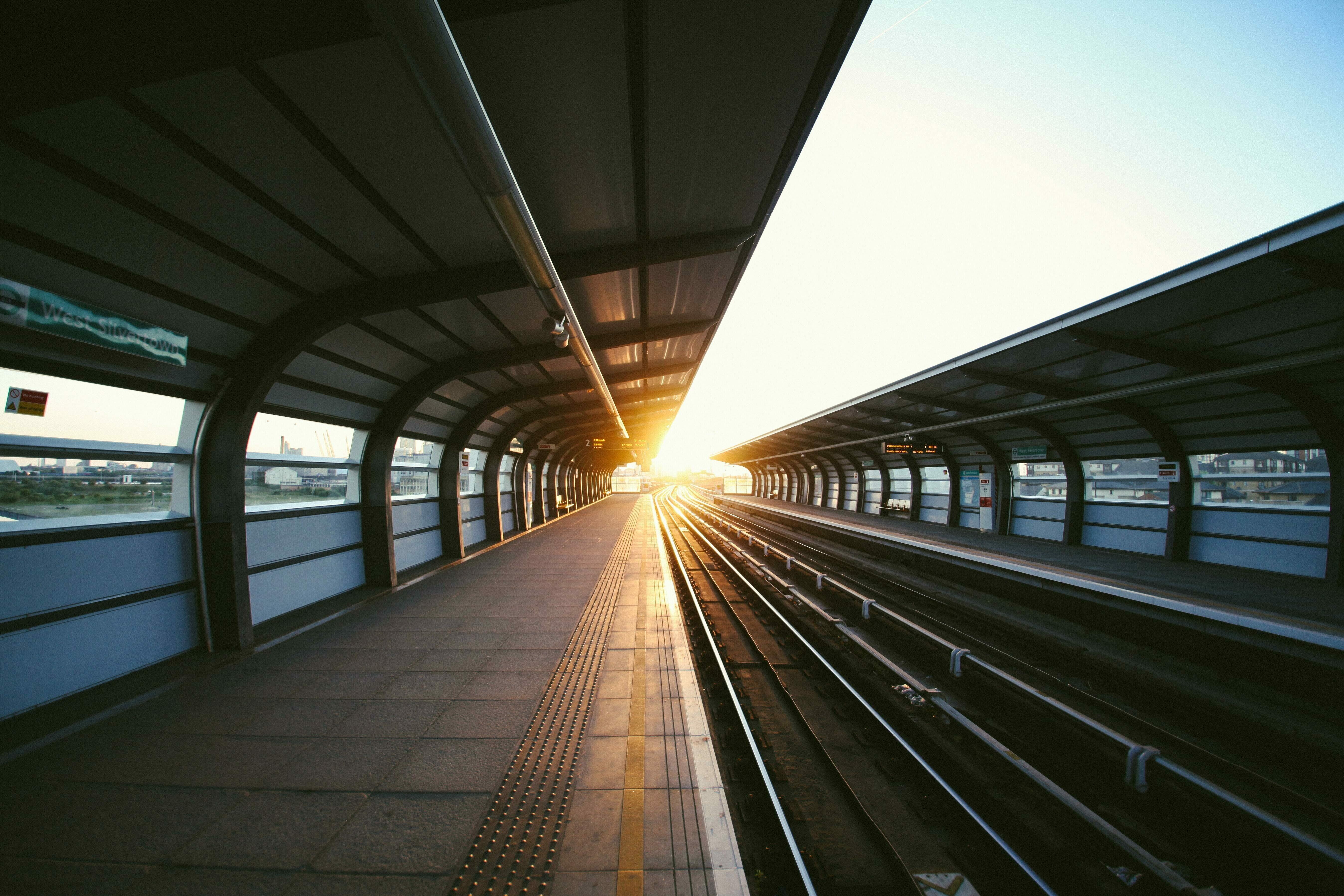 Ein langer, leerer Bahnsteig vor untergehender Sonne.