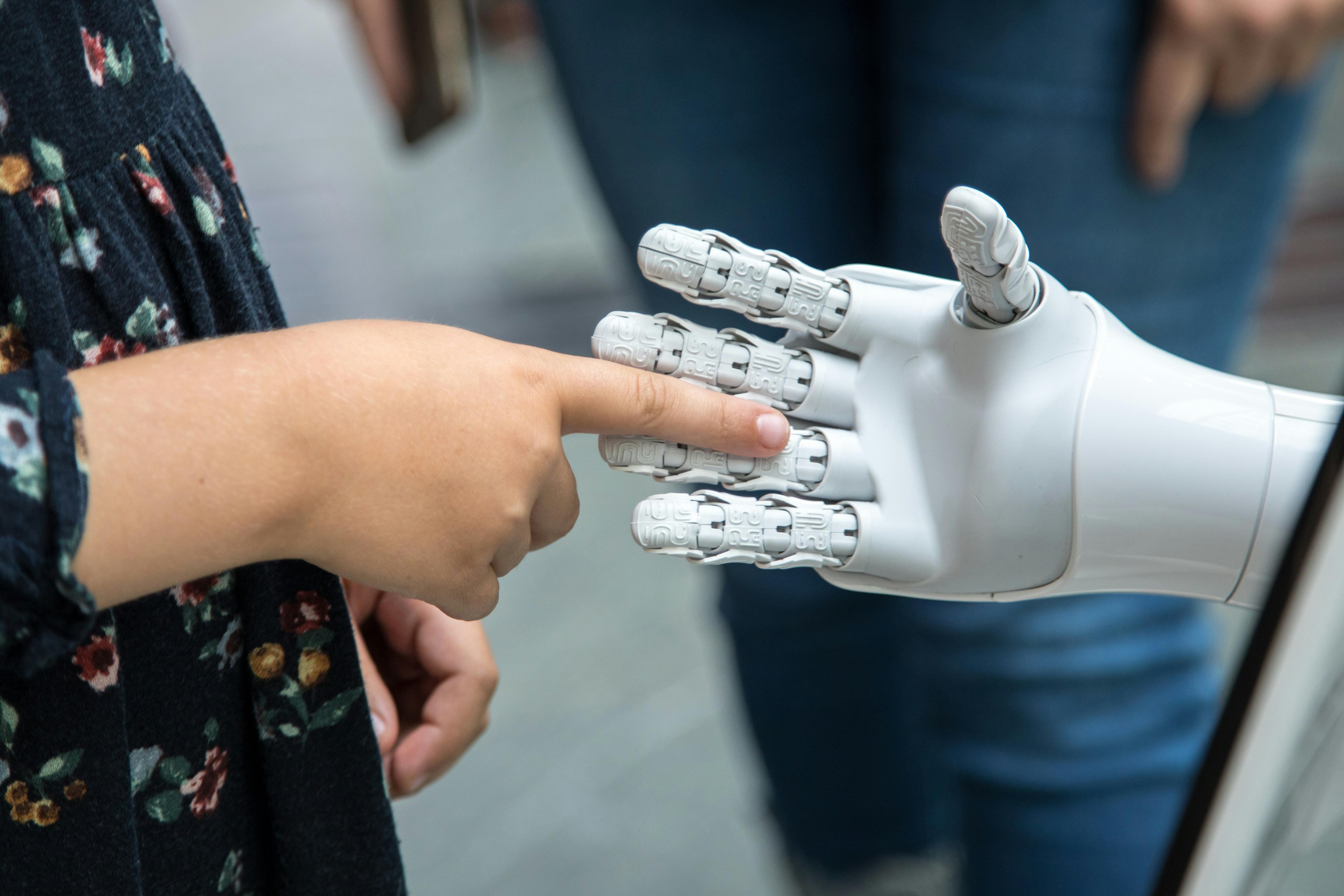 Kinderhand berührt Roboterhand