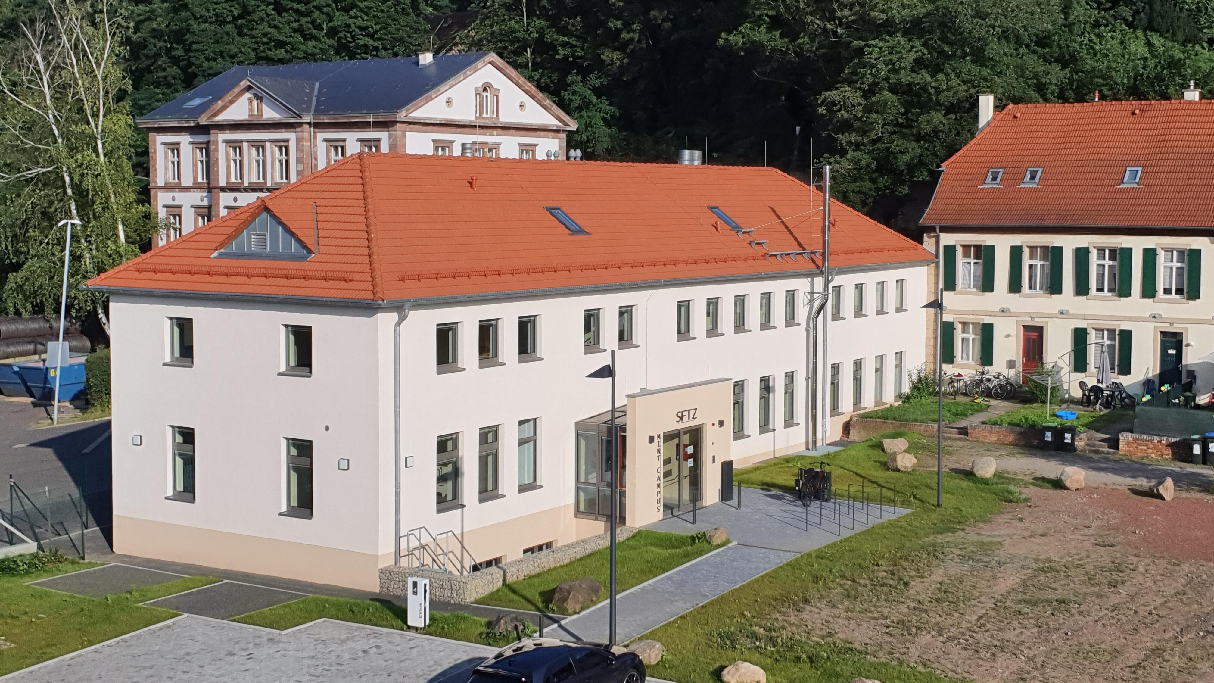 Das Schülerforschungs- und -technikzentrum (SFTZ) steht im Areal Alte Schmelz, einem denkmalgeschützten Ensemble historischer Industriebauten (ehemaliges Eisenwerk). Es ist aus dessen Laborgebäude hervorgegangen. Die Umbaukosten betrugen 3,3 Mio. €. Die offizielle Eröffnung hat im Juli 2021 stattgefunden.