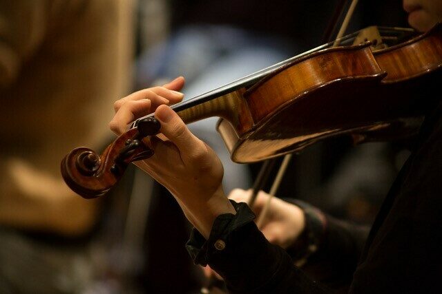 Eine Musikerin, die Geige spielt.