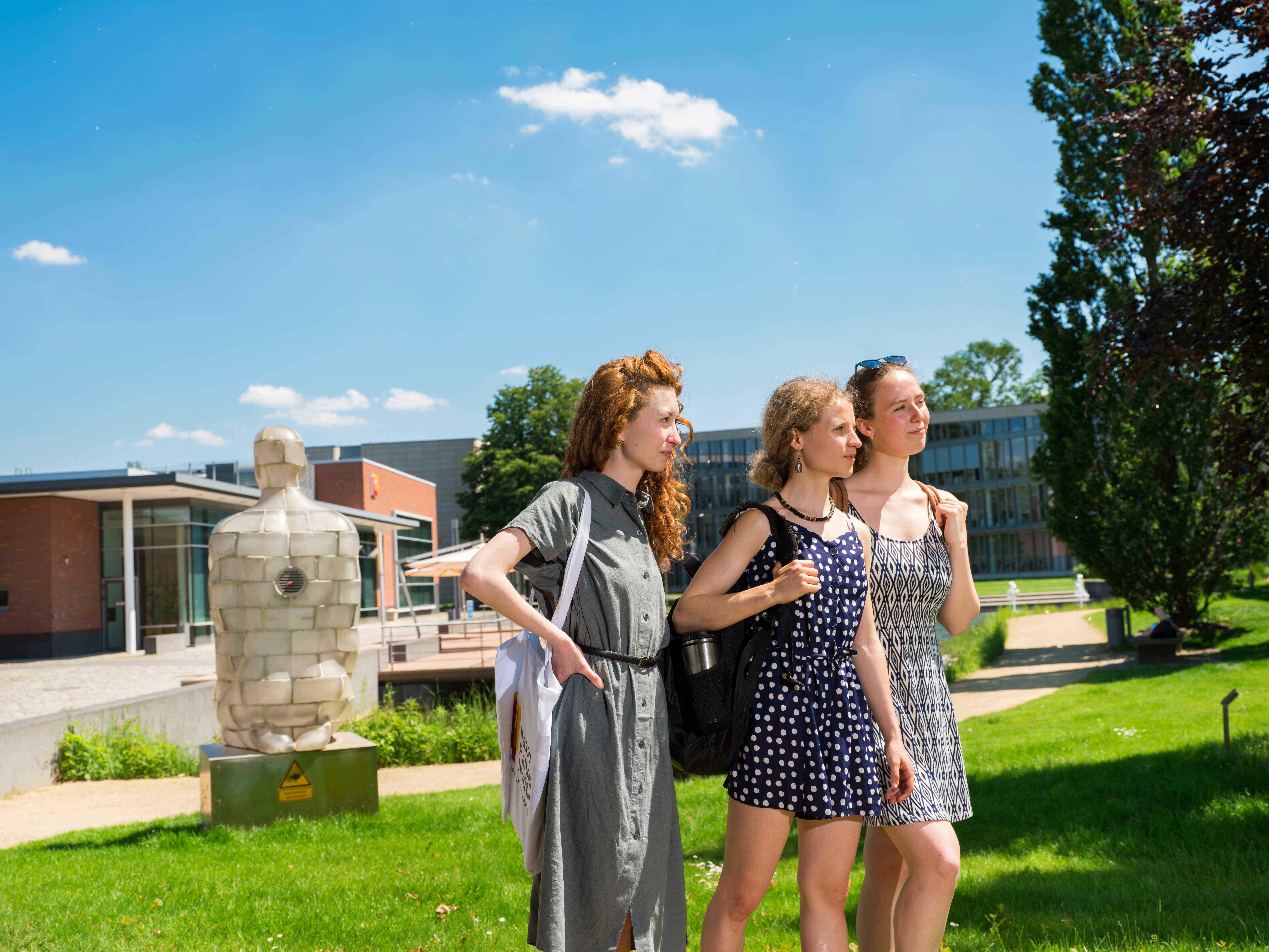 Abbildung von drei Informatik-Studentinnen, die Reisestipendien erhalten könnten.