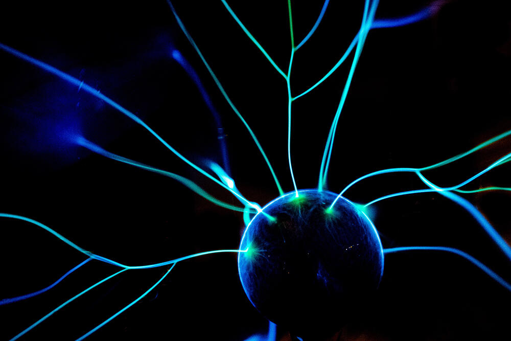 Blaue Licht- und Laserstrahlen vor dunklem Hintergrund.