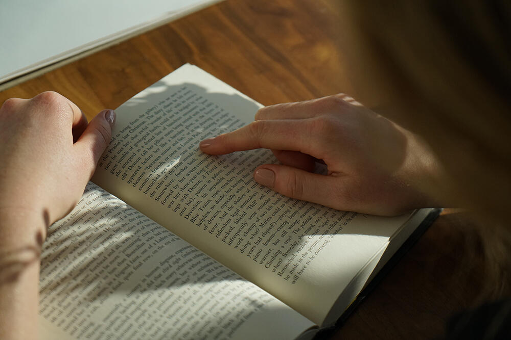 Schülerin, die in einem Buch liest.