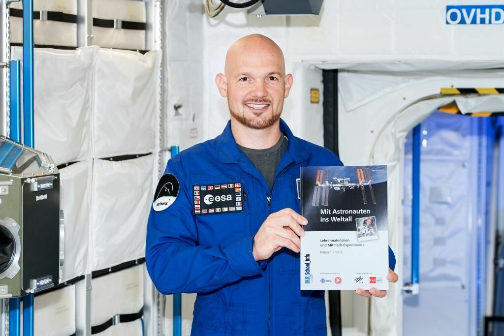 Bild von Alexander Gerst mit Schulheft "Mit Astronauten ins Weltall"