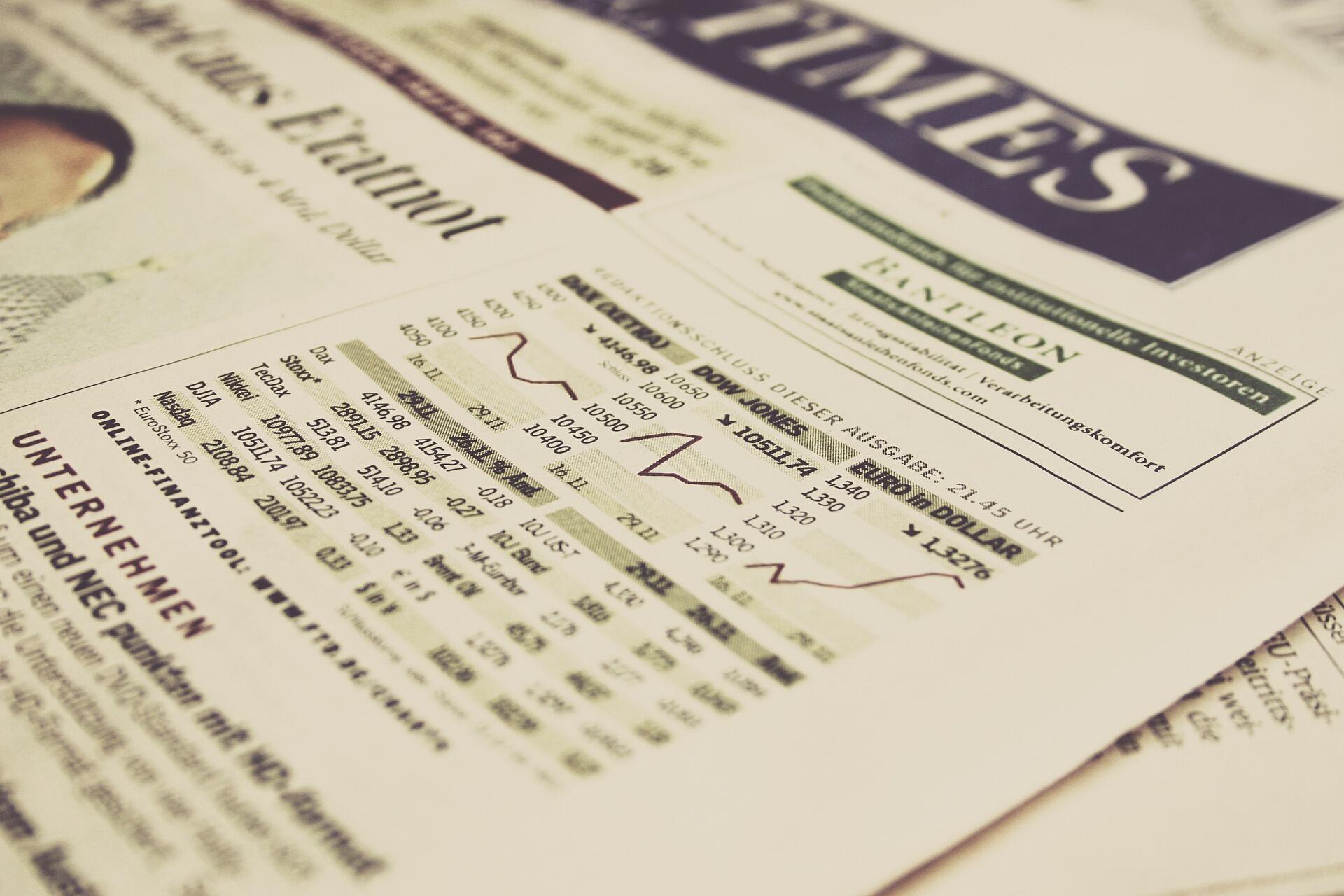 Ausschnitt der Finanzseite einer Zeitung mit Angabe der Aktienindexe Dax und Dow Jones.