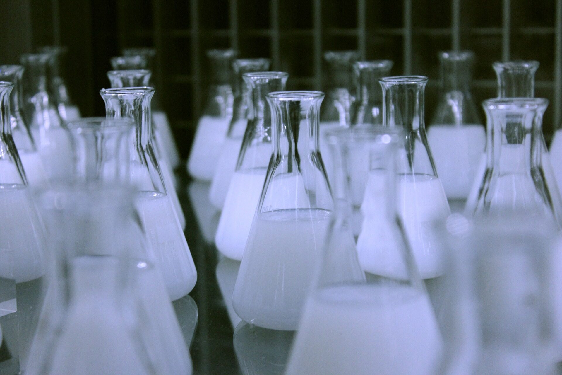 Eine Reihe von Laborgläsern mit weißer Flüssigkeit