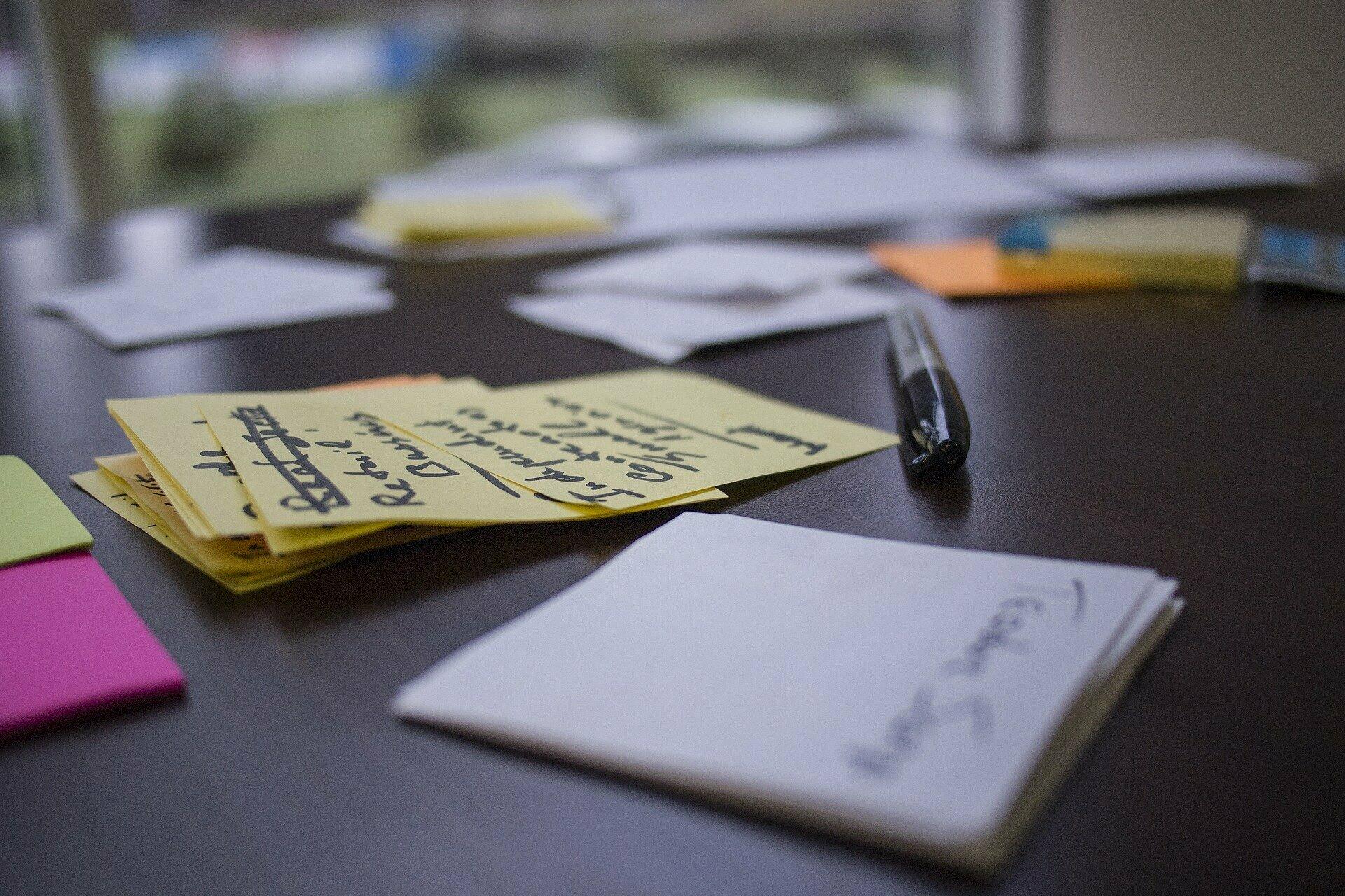 Arbeitsmaterialien wie Post-its und Stifte zur Veranschaulichung von Arbeitsphasen beim Design Thinnking und Brainstorming.