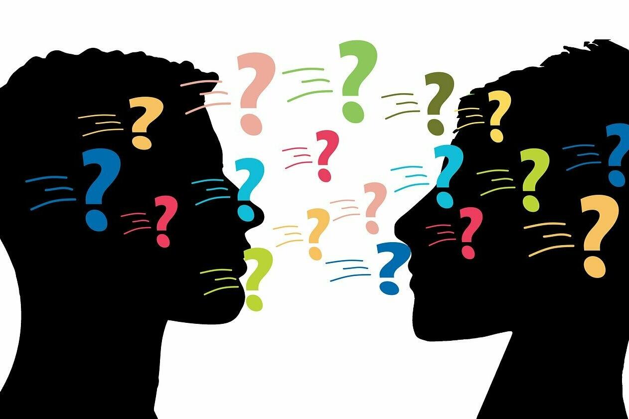 Dialog: Grafische Darstellung von zwei Köpfen, die einander zugewandt sind, und Fragezeichen, die im Raum stehen.
