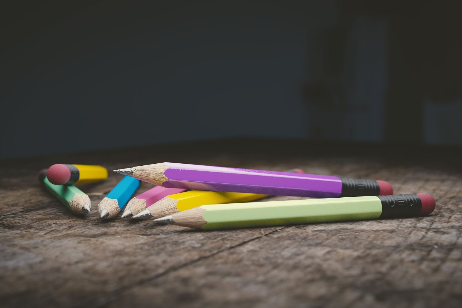 Verschiedene bunte Bleistifte, die auf einem Holztisch liegen