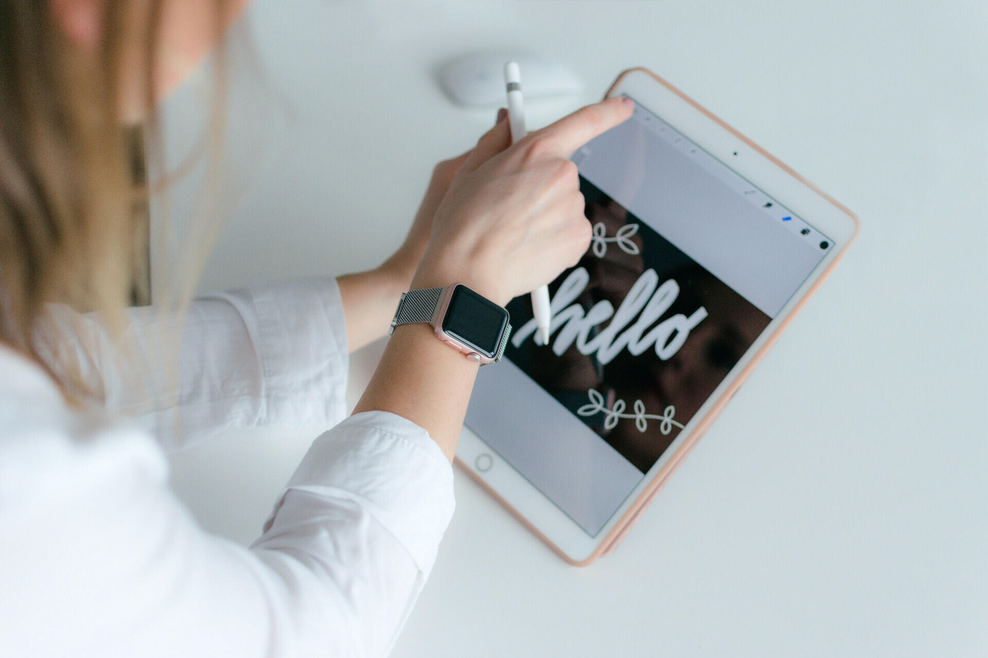 Eine Frau hält ein Table mit der Aufschrift "Hello" in der Hand.