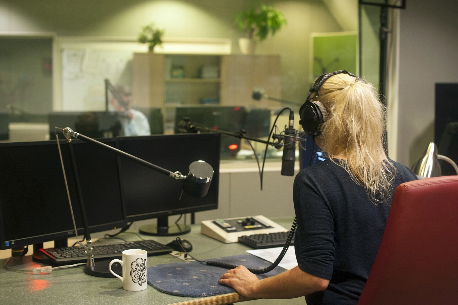Abbildung einer jungen Frau, die eine Radiosendung aufnimmt oder moderiert.