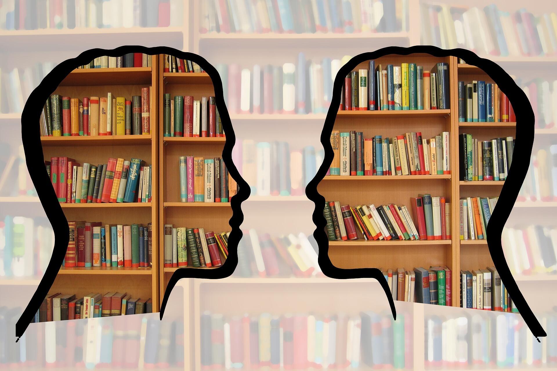Die Umrisse von zwei Köpfen vor einem Bücherregal
