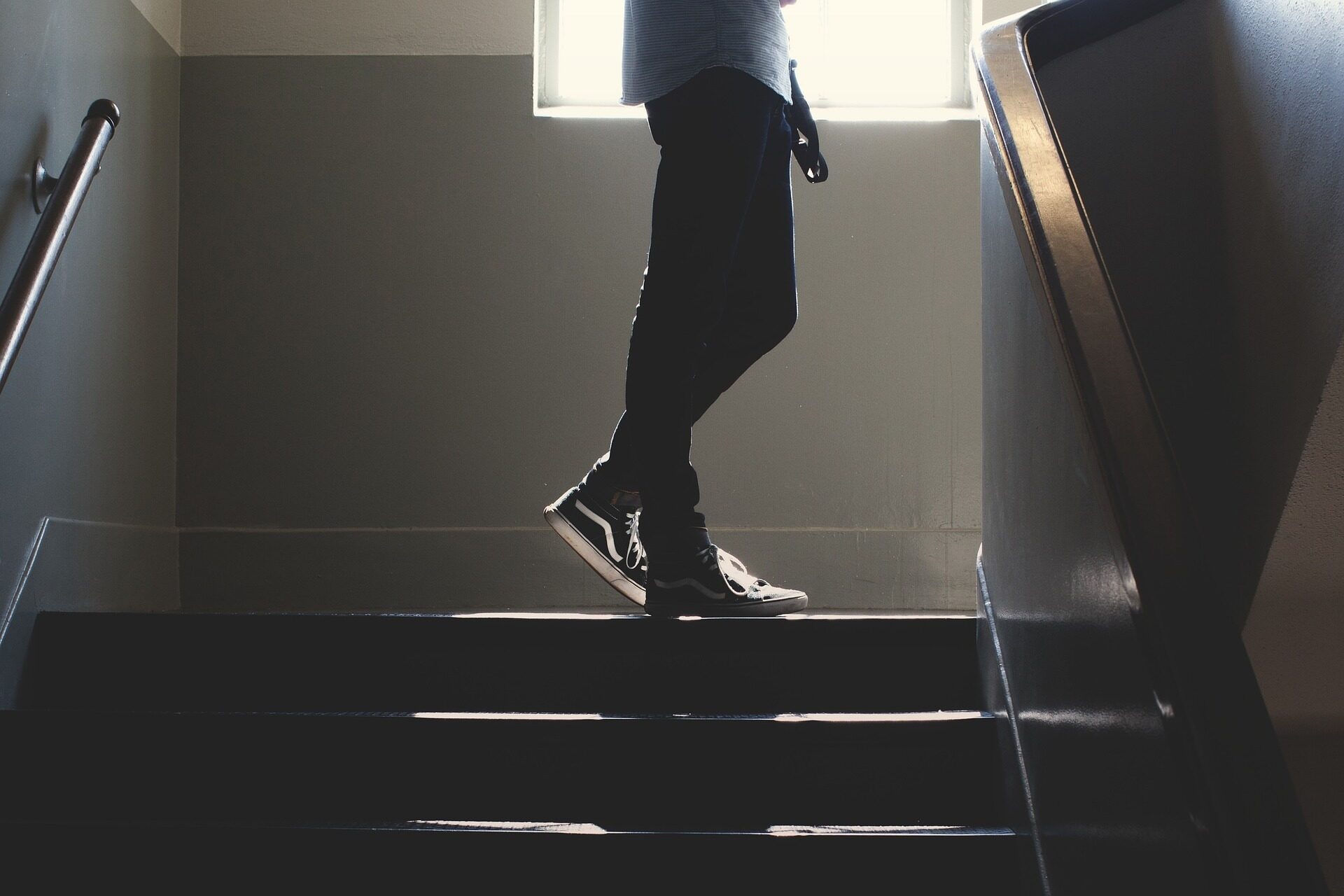 Beine eines Jugendlichen, in auf der Treppe im Hausflur steht.