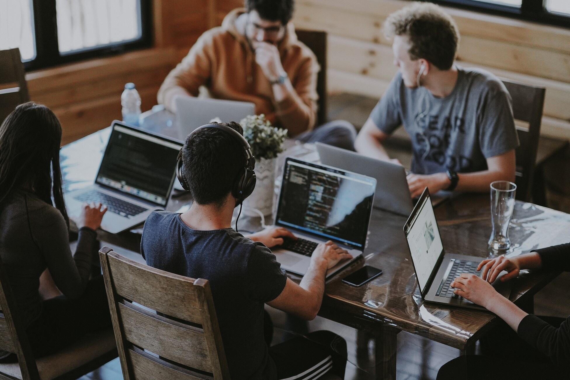 Studenten sitzen am Tisch mit Laptops