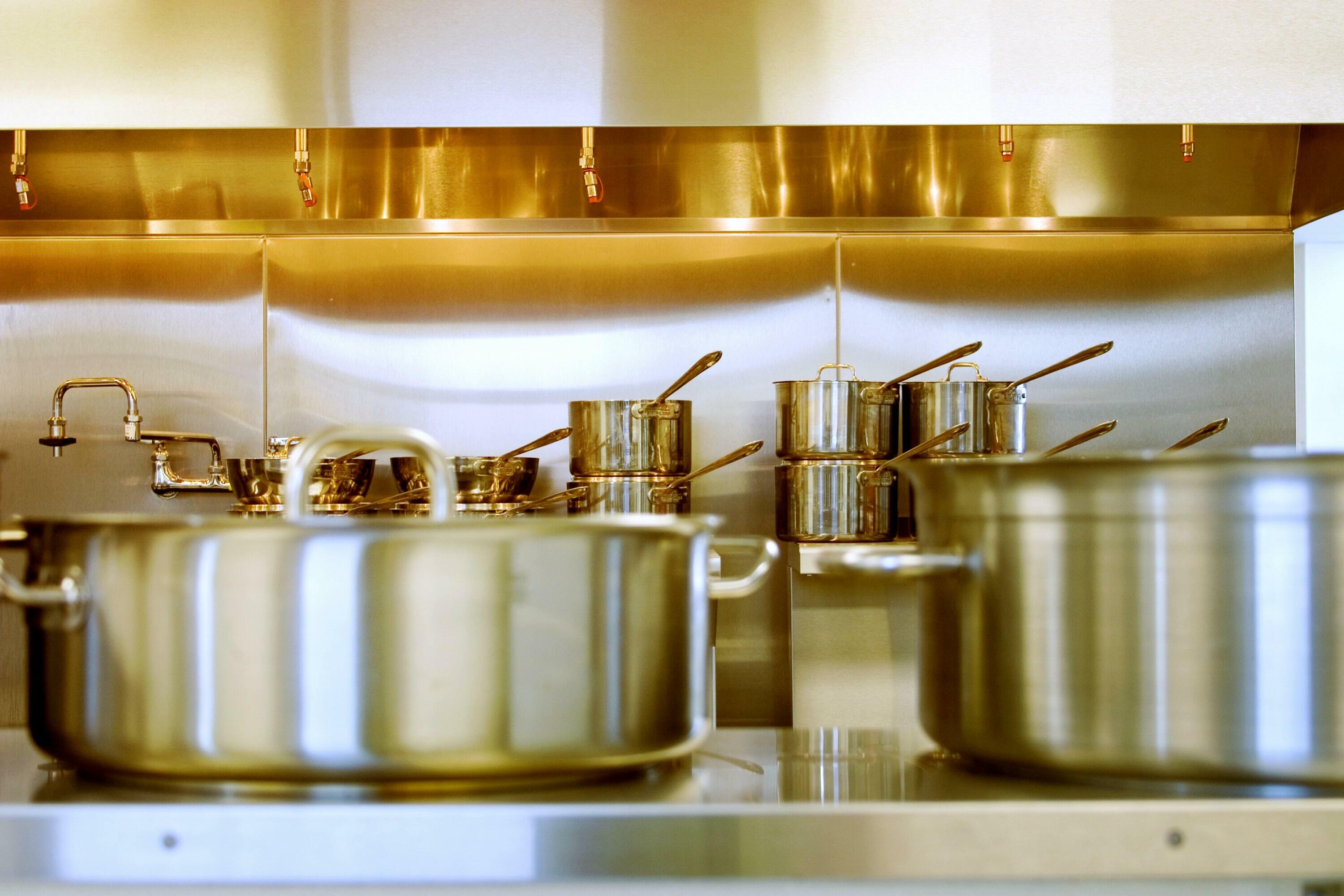 Töpfe aus Edelstahl in der Küche eines Restaurants.