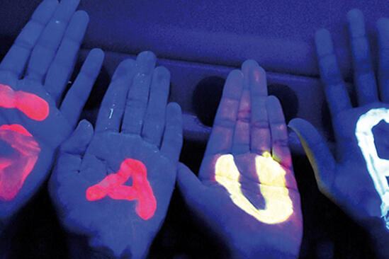Hände im Neonlicht auf denen der Name GAUß steht.