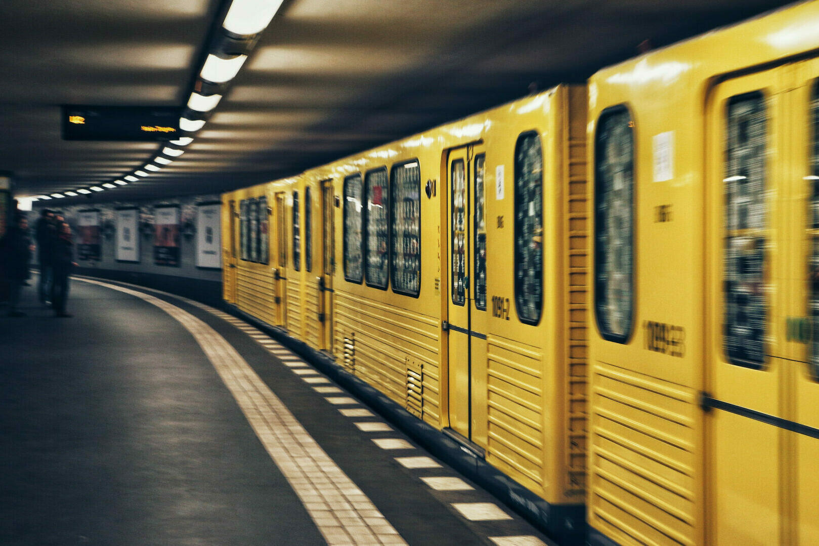 Eine gelbe U-Bahn, die Fahrt aufnimmt.